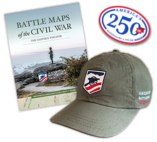 Various magazine covers stacked on top of one another, a baseball hat with an American Battlefield Trust logo and a man wearing a hoodie with an American Battlefield Trust logo design on it.
