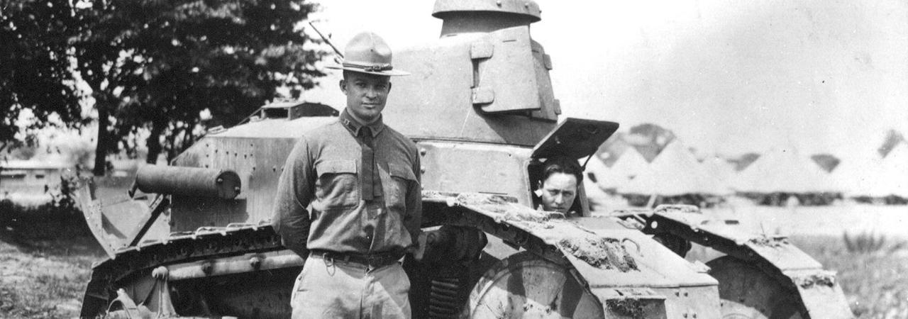 A black and white photo of Maj. Dwight D. Eisenhower beside a Renault light tank