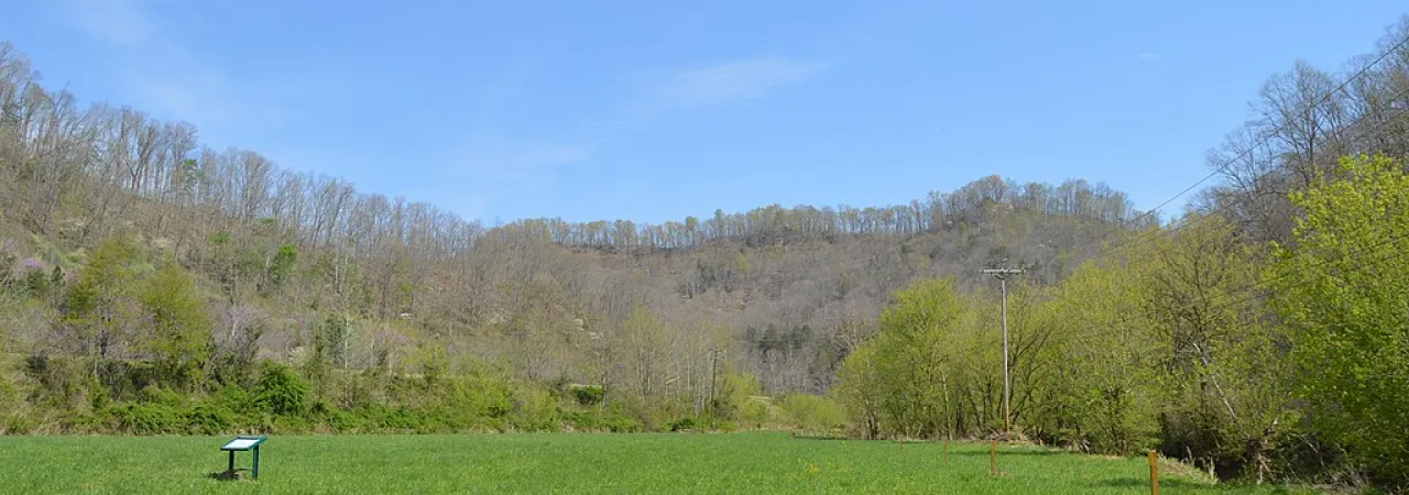 Battlefield with a sign in the mid-ground.