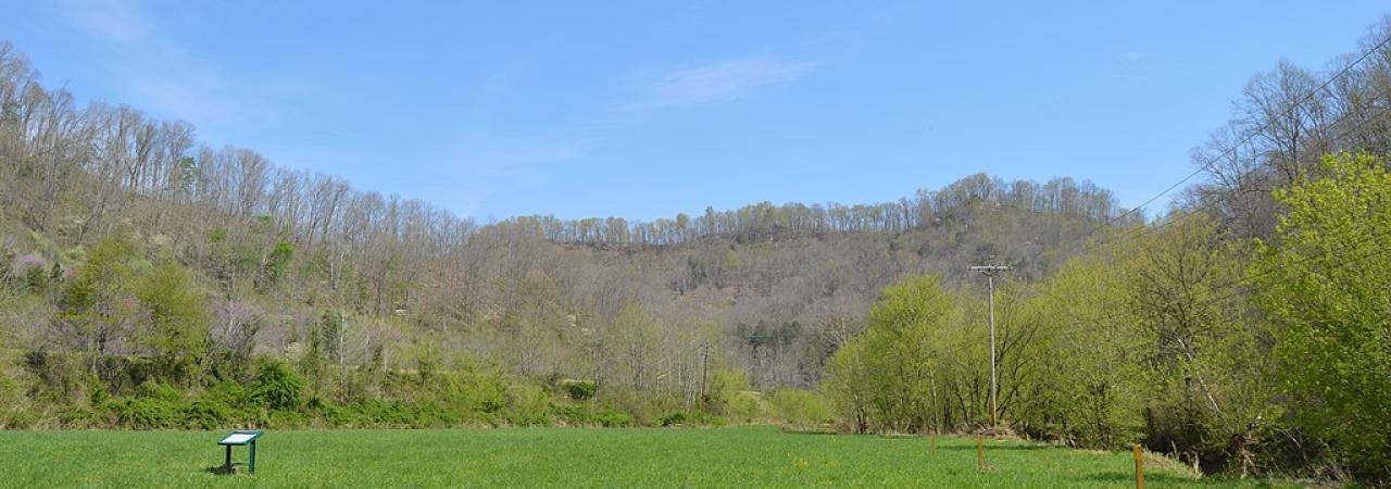 Battlefield with a sign in the mid-ground.