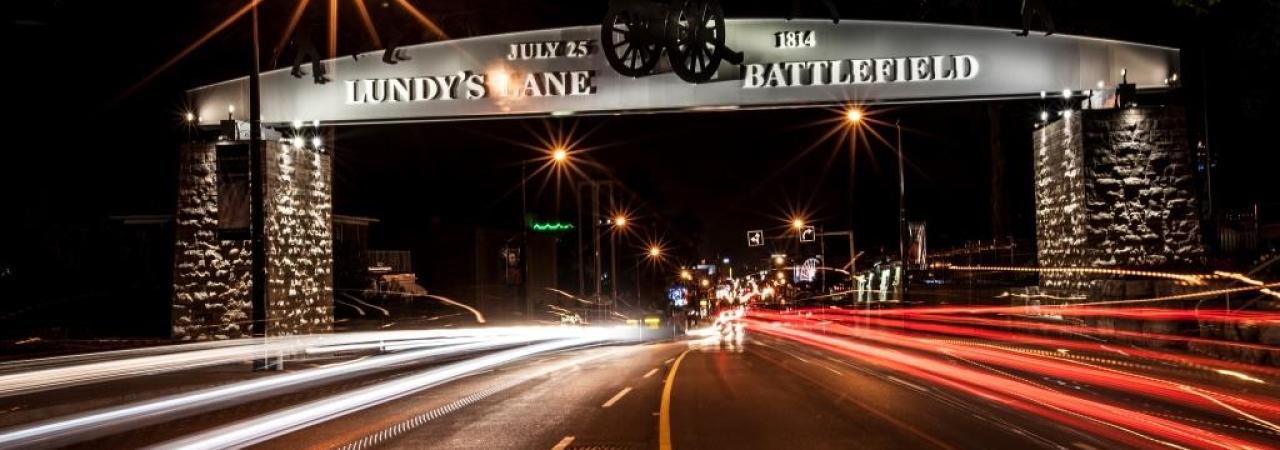 Photograph of an arch at nighttime that reads "Lundy's Lane Battlefield"