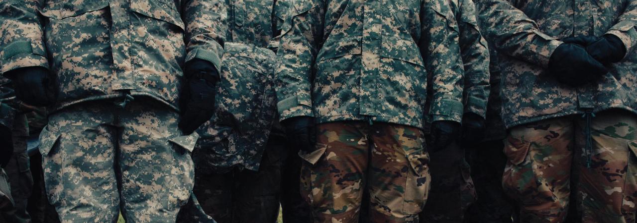 View of group cadets from the chest down wearing fatigues and boots on grass