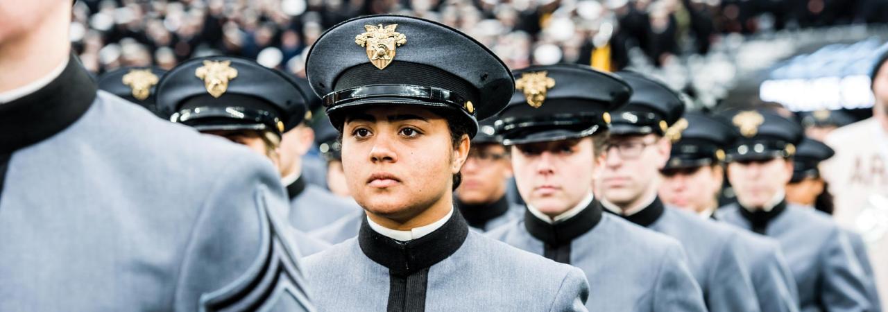 Image focused on female West Point cadet parading in at stadium