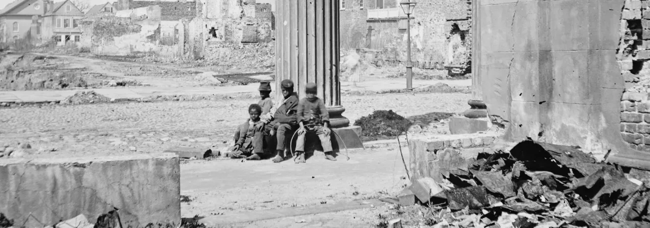 Civil War-era photograph showing ruined buildings in Charleston, South Carolina, framed by the porch of the Circular Church at 150 Meeting Street.