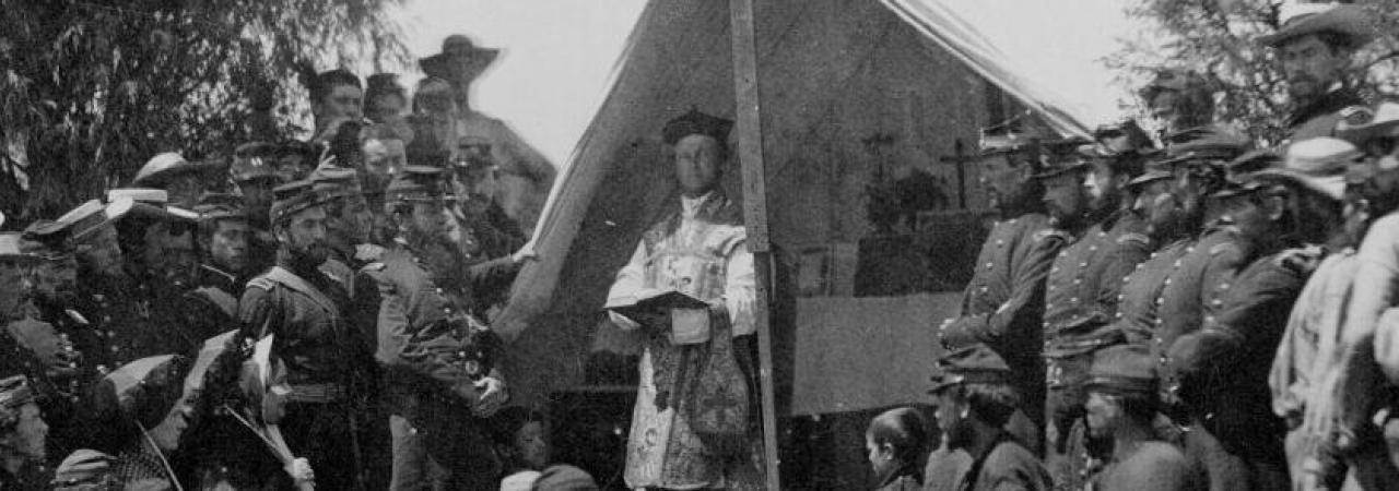 Photograph of a chaplain preaching to soldiers in a camp