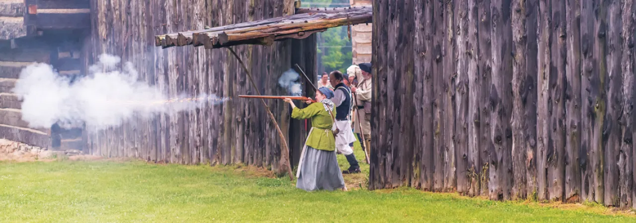 This is an image of a woman firing a gun at Logan's Fort.
