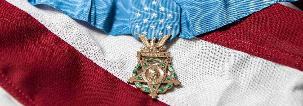 A picture of a Medal of Honor on top of an American flag