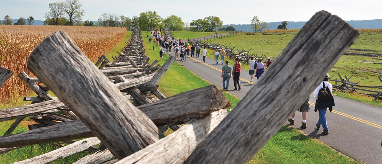 This is an image of battlefield fencing amidst people touring a battlefield. 