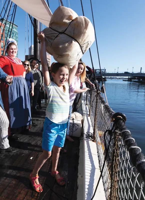 A young visitor tosses tea overboard at the Boston Tea Party Ships & Museum.