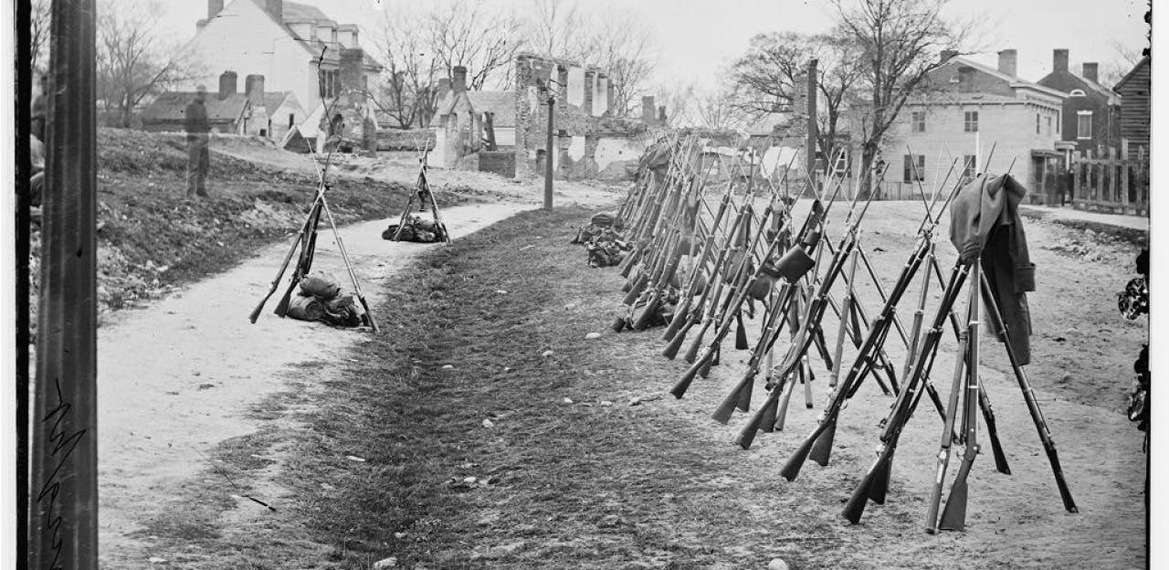 Petersburg, Va. Row of stacked Federal rifles; houses beyond
