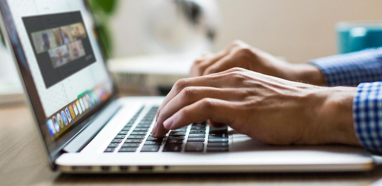 An online participant watches a webinar on their laptop.