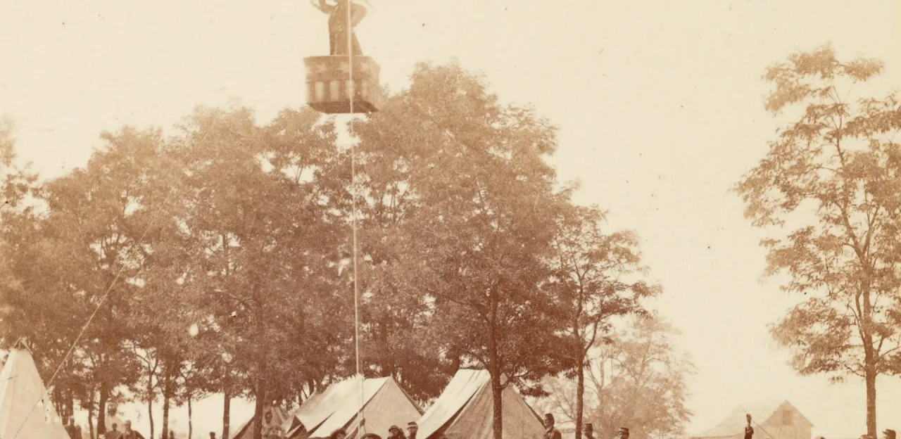 Union Army aeronaut Thaddeus S. C. Lowe observes the Battle of Fair Oaks, Virginia, from his observation balloon Intrepid, while soldiers below hold its tethering ropes.
