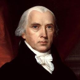 Portrait of President James Madison wearing a black coat and white cravat, seated before a red drapery with books visible in the background.