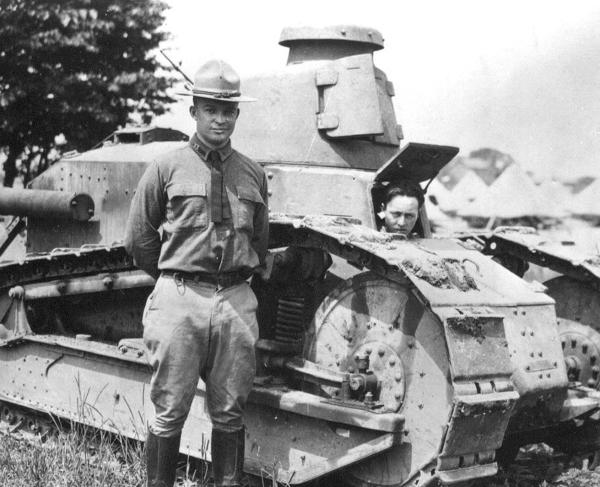 A black and white photo of Maj. Dwight D. Eisenhower beside a Renault light tank