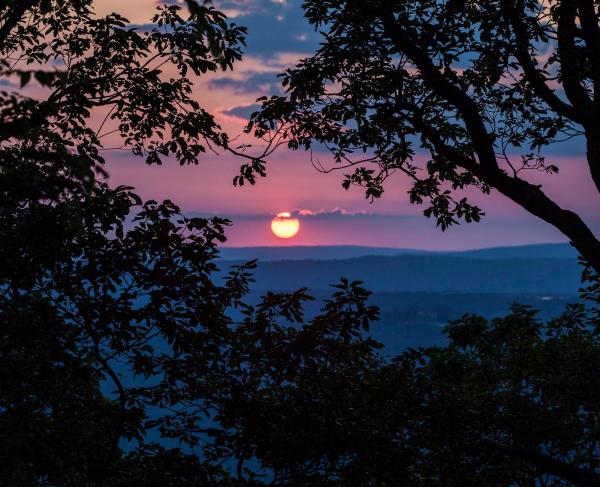 The sun setting over the Chattanooga Battlefield.  Trees silhouetted in the foreground.