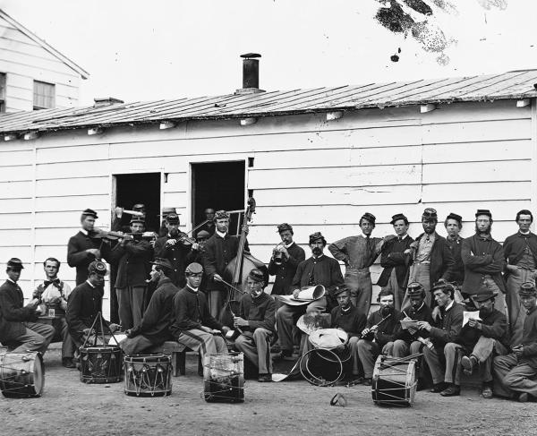 Black and white group photo of soldiers in uniform with drums