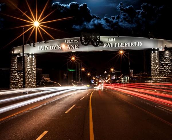 Photograph of an arch at nighttime that reads "Lundy's Lane Battlefield"