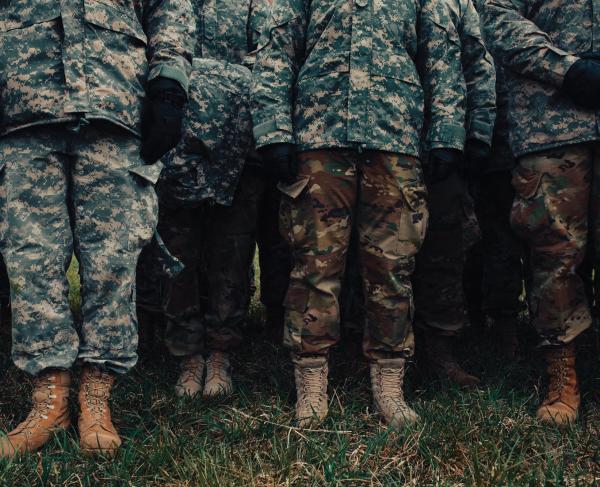 View of group cadets from the chest down wearing fatigues and boots on grass