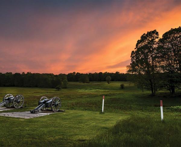 Two cannons on the Saratoga Battlefield at sunset