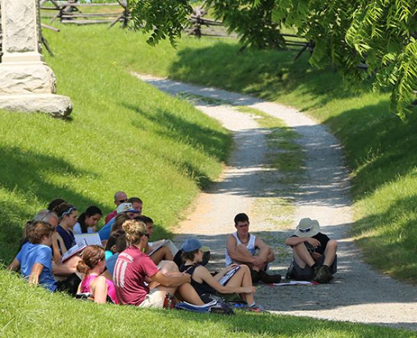 This is an image of a tour group sitting on the Antietam battlefield. 
