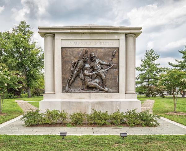 Stone memorial with a bronze bas-relief of three military officers