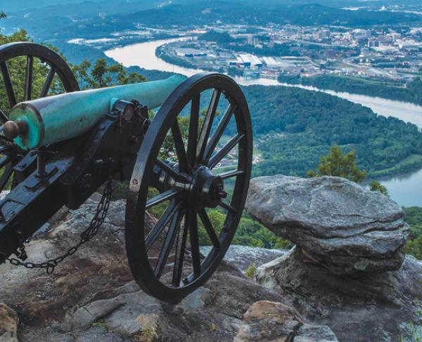 Cannon on the edge of a mountain overlooking a winding river below