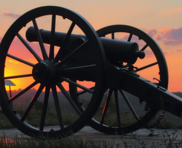 This is an image of a cannon resting in Lexington, Kentucky during a vibrant sunset. 