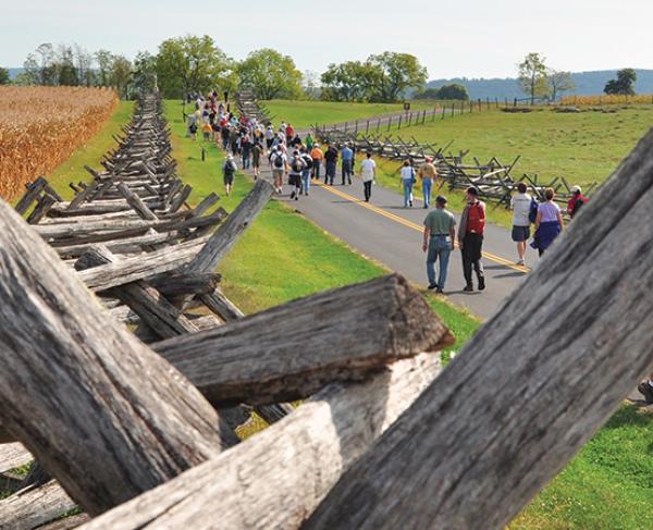 This is an image of battlefield fencing amidst people touring a battlefield. 