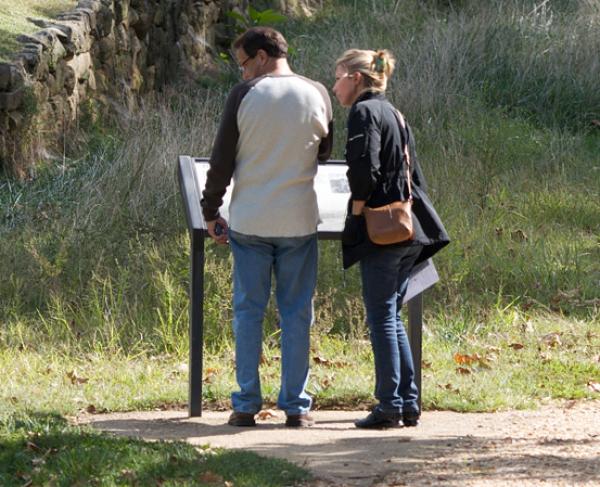 This photo depicts two people learning about Fredericksburg while walking on the grounds of this battlefield. 
