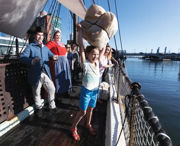 A young visitor tosses tea overboard at the Boston Tea Party Ships & Museum.