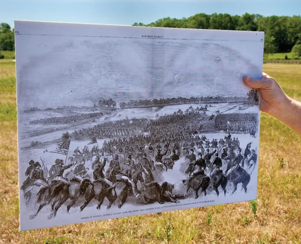 A hand holds an illustration of the Battle of Brandy Station at Brandy Station Battlefield, Va.