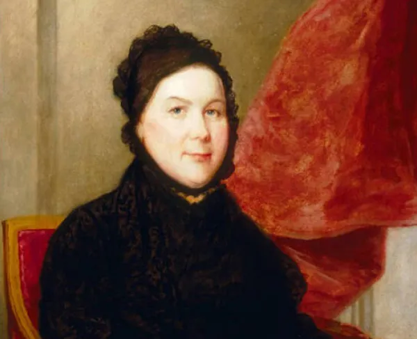 Image shows portrait of Catharine Greene as an older woman wearing a black dress, sitting at chair in front of red curtains. 