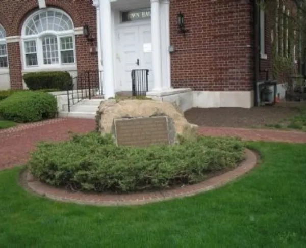 A bronze plaque mounted on a stone surrounded by greenery commemorates a June 23, 1780 militia action that halted a British advance toward Morristown.