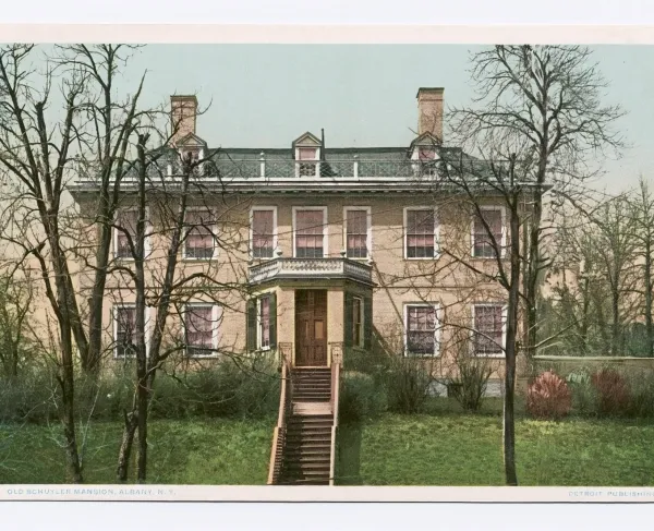 Postcard depicting colonial home showing two chimneys, dormer windows, covered entry and steps leading to front door.