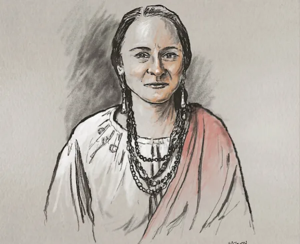 A Native American woman wearing necklaces and a blanket draped over her shoulder. 
