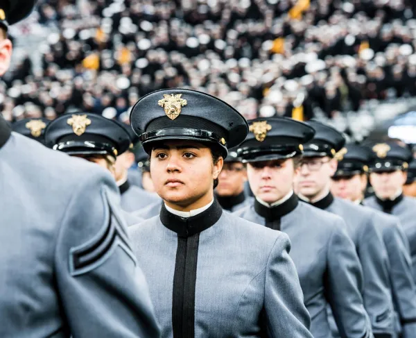 Image focused on female West Point cadet parading in at stadium
