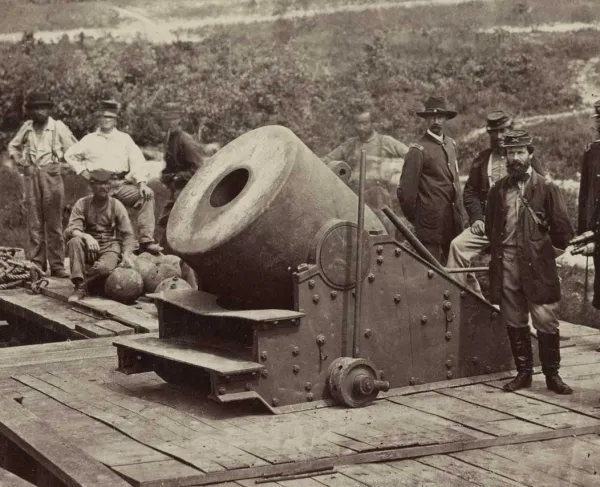Photograph of soldiers standing in front of a cannon