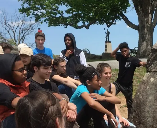 This is an image of a tour guide presenting to a group at a battlefield. 