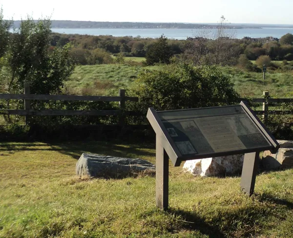 The Narransett Bay, where the French fleet arrived prior to the Battle of Rhose Island, can be seen behind the interpretive marker at Rhode Island Battlefield in Portsmouth, Rhode Island. 