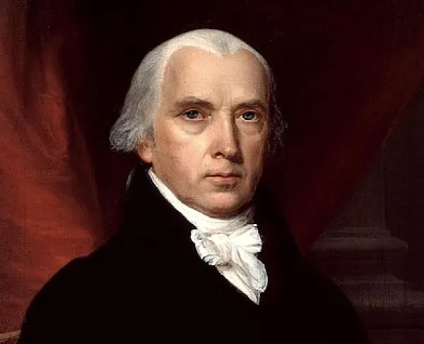 Portrait of President James Madison wearing a black coat and white cravat, seated before a red drapery with books visible in the background.