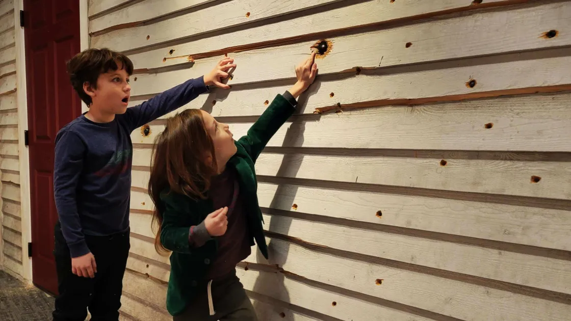 Young people investigate a replica battle-damaged wall at the Gettysburg Beyond the Battle Museum