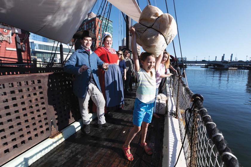 A young visitor tosses tea overboard at the Boston Tea Party Ships & Museum.