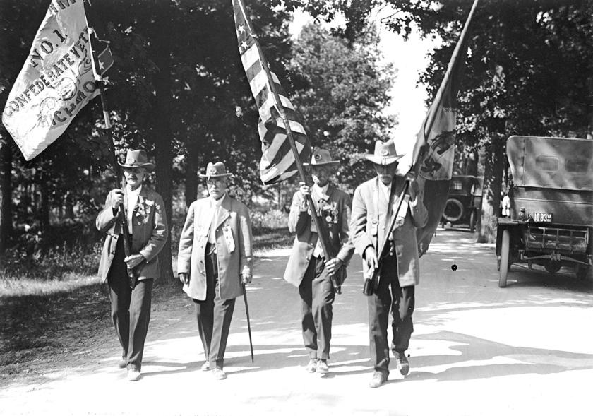 A balck and white photo of Union and Confederate veterans marching together
