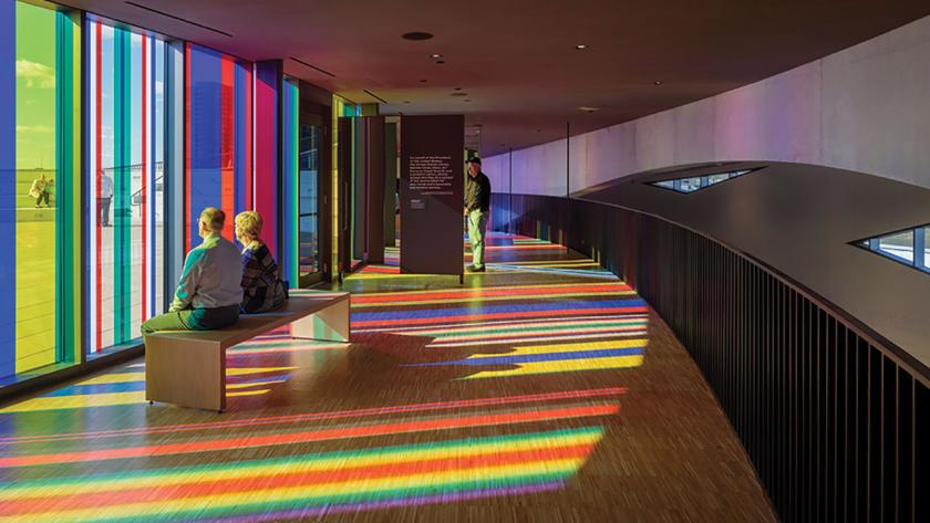 Vistors sit in rainbow colored light in a hall at the National Veterans Memorial Museum, Columbus, Ohio