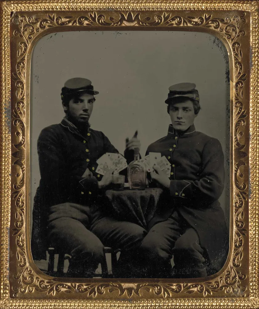 Two unidentified soldiers in Union uniforms drinking whiskey and playing cards