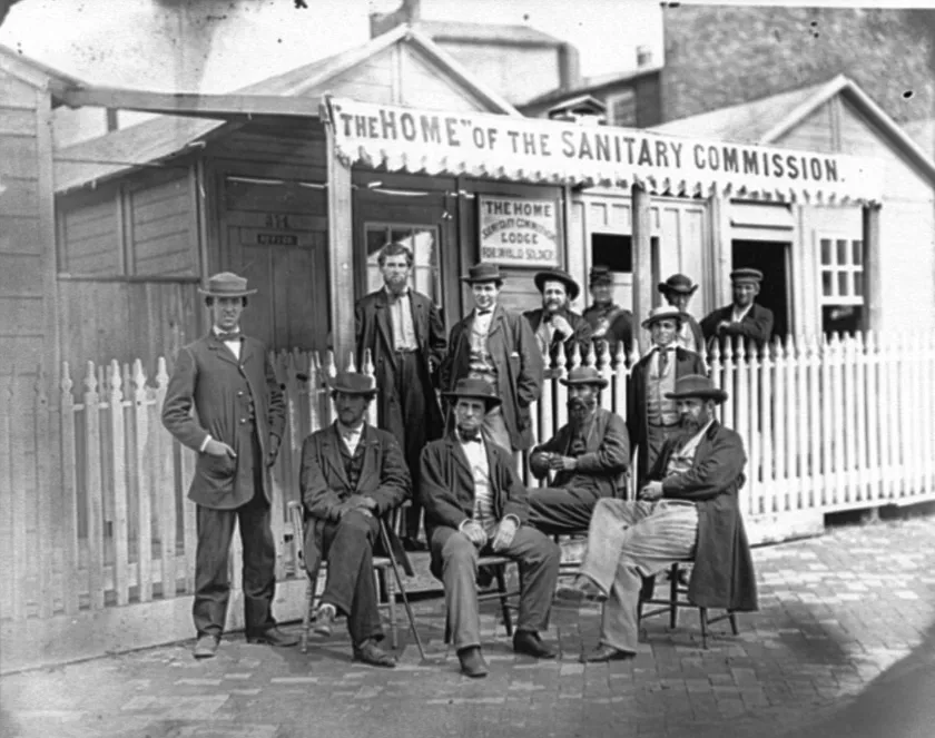 Group photograph of United States Sanitary Commission workers gathered outside the entrance to the Home Lodge in Washington, D.C.