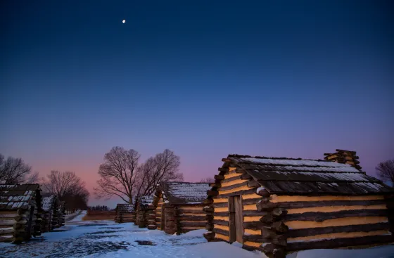 Snow at dawn near the recreated cabins at Valley Forge National Historical Park in King of Prussia, Pa.
