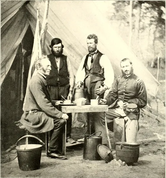 Union soldiers and civilians gather around a table for coffee