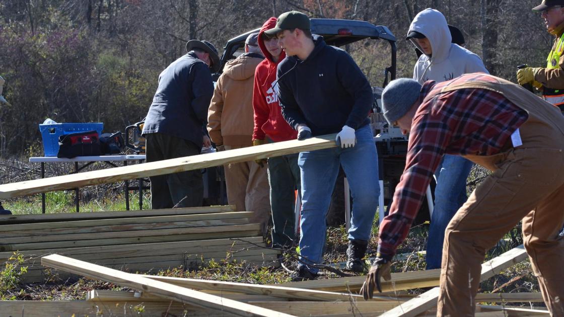 Volunteers stack planks of wood at a Park Day event
