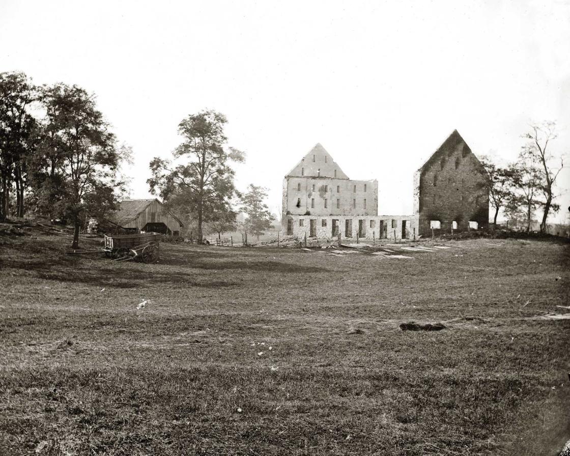 A black and white photo of the original barn after the Civil War.